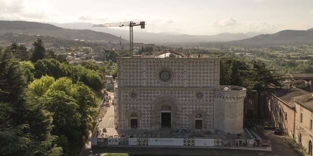 Luftbild der Basilica di Santa Maria di Collemaggio in L'Aquila - im Hintergrund ein Baukran Luftbild der Basilica di Santa Maria di Collemaggio in L'Aquila - im Hintergrund ein Baukran