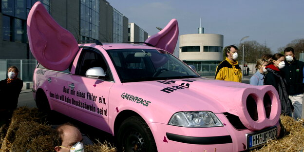 ein rosafarbenes Auto mit Schweineschnauze und -ohren ein rosafarbenes Auto mit Schweineschnauze und -ohren