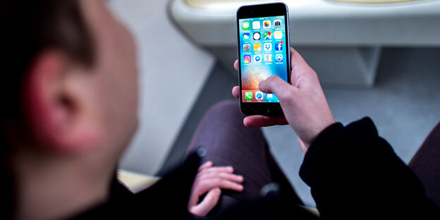 Eine Person hält ein Smartphone Eine Person hält ein Smartphone