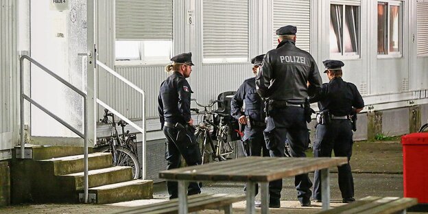 Polizisten vor Wohncontainer Polizisten vor Wohncontainer
