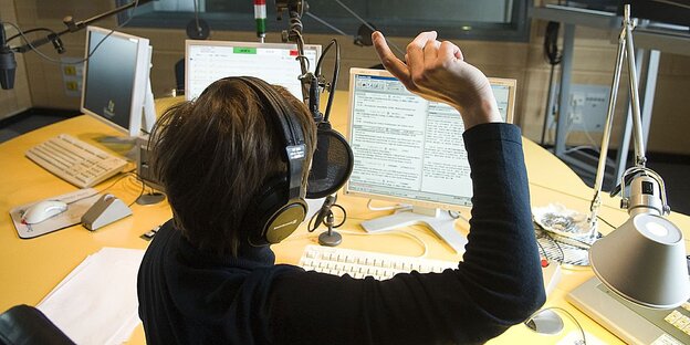 Eine Person sitzt in einem Aufnahmestudio. Eine Person sitzt in einem Aufnahmestudio.