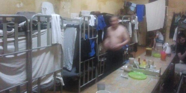 Ein nicht zu erkennender Mann durchschreitet einen Schlafsaal in der Arbeitskolonie LIU-19 im russischen Mordwinien. Ein nicht zu erkennender Mann durchschreitet einen Schlafsaal in der Arbeitskolonie LIU-19 im russischen Mordwinien.
