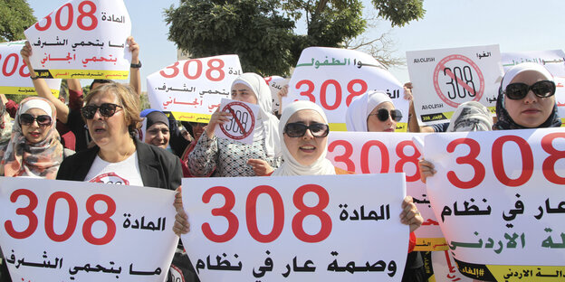 Demonstrantinnen halten Plakate hoch, auf denen unter anderem auf arabisch steht: „Artikel 308 schützt nicht die Ehre, sondern den Täter“ Demonstrantinnen halten Plakate hoch, auf denen unter anderem auf arabisch steht: „Artikel 308 schützt nicht die Ehre, sondern den Täter“