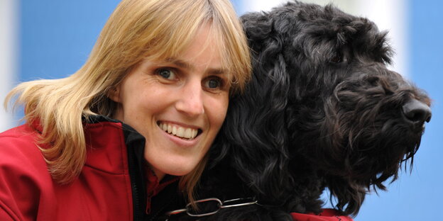 Ein blonde Frau mit einem schwarzen Hund Ein blonde Frau mit einem schwarzen Hund