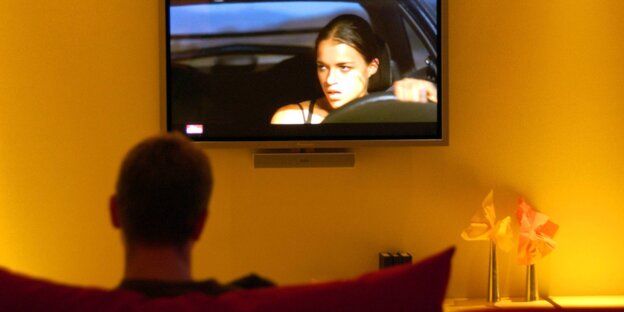 Ein Mann sitzt vor dem Fernseher Ein Mann sitzt vor dem Fernseher