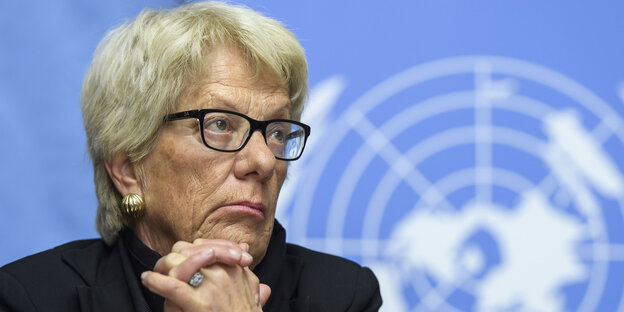 Carla Del Ponte hat das Kinn auf die verschränkten Hände gestützt und guckt durch ihre schwarz gerahmte Brille resigniert zur Seite Carla Del Ponte hat das Kinn auf die verschränkten Hände gestützt und guckt durch ihre schwarz gerahmte Brille resigniert zur Seite