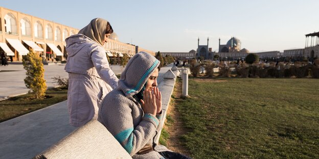 Auf dem Königsplatz in Isfahan sitzen zwei Frauen im Abendlicht. Auf dem Königsplatz in Isfahan sitzen zwei Frauen im Abendlicht.