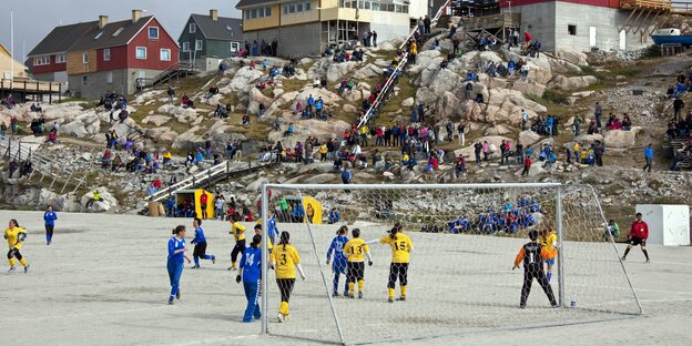 Frauen spielen auf einem schneebedeckten Feld Fußball