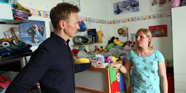 Ein Mann und eine Frau stehen in einem Kinderzimmer Ein Mann und eine Frau stehen in einem Kinderzimmer