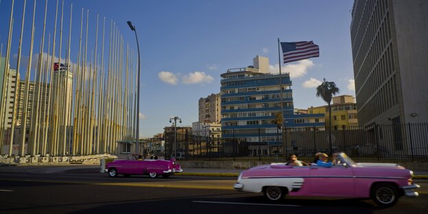 Autos vor einem Gebäude, auf dem die US-Flagge weht Autos vor einem Gebäude, auf dem die US-Flagge weht