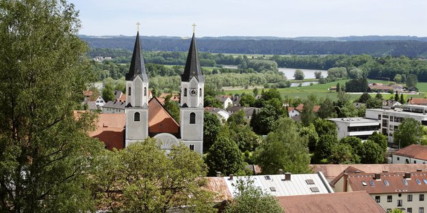Zwei Kirchtürme in einem Dorf vor sommerlicher Landschaft Zwei Kirchtürme in einem Dorf vor sommerlicher Landschaft