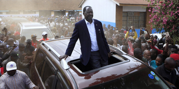 Raila Odinga fährt stehend in einem Auto durch eine Menge von Anhängern. Raila Odinga fährt stehend in einem Auto durch eine Menge von Anhängern.