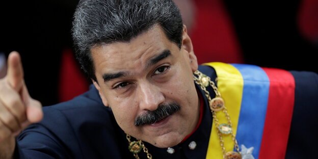 Ein Mann mit einer Schärpe in den Nationalfarben Venezuelas und erhobenem rechten Zeigefinger Ein Mann mit einer Schärpe in den Nationalfarben Venezuelas und erhobenem rechten Zeigefinger