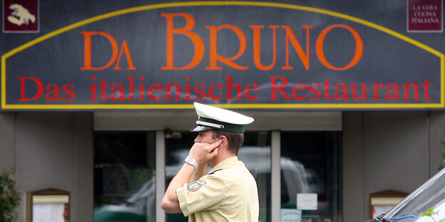 Ein Polizist telefoniert vor dem Restaurant "Da Bruno" Ein Polizist telefoniert vor dem Restaurant "Da Bruno"