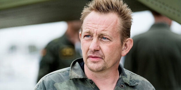 Peter Madsen steht im tarngrünen Hemd da und blickt in die Ferne Peter Madsen steht im tarngrünen Hemd da und blickt in die Ferne