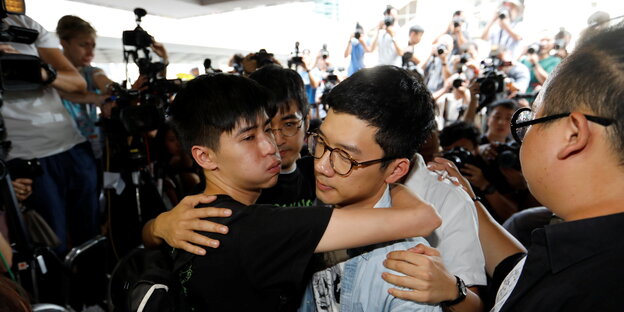 Die Sudenten Lester Shum, Nathan Law und Alex Chow umarmen sich vor dem Gericht Die Sudenten Lester Shum, Nathan Law und Alex Chow umarmen sich vor dem Gericht