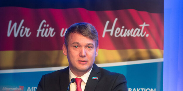 AfD-Politiker Poggenburg steht vor einem AfD-Plakat AfD-Politiker Poggenburg steht vor einem AfD-Plakat