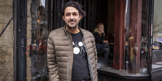 Ein Mann mit dunklen Haaren in einer hellbraunen Jacke Ein Mann mit dunklen Haaren in einer hellbraunen Jacke