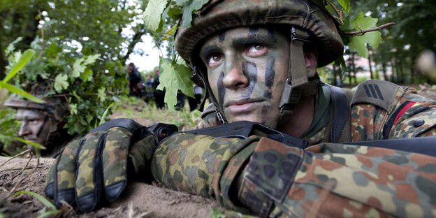 Ein mit Tarnfarben geschminkter Soldat Ein mit Tarnfarben geschminkter Soldat