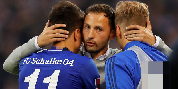 Ein Mann, Tedesco, umarmt zwei Spieler in blauen Trikots Ein Mann, Tedesco, umarmt zwei Spieler in blauen Trikots