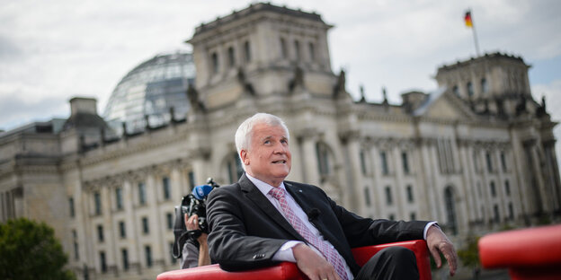 Horst Seehofer sitzt in einem roten Sessel, im Hintergrund der Berliner Reichstag Horst Seehofer sitzt in einem roten Sessel, im Hintergrund der Berliner Reichstag