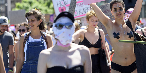 Frauen auf einer Demo, eine hat ihr Gesicht verummt. eine andere ist barbusig Frauen auf einer Demo, eine hat ihr Gesicht verummt. eine andere ist barbusig