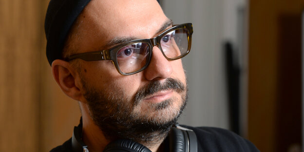 Ein Mann mit Brille, Wollmütze und Kopfhörern Ein Mann mit Brille, Wollmütze und Kopfhörern