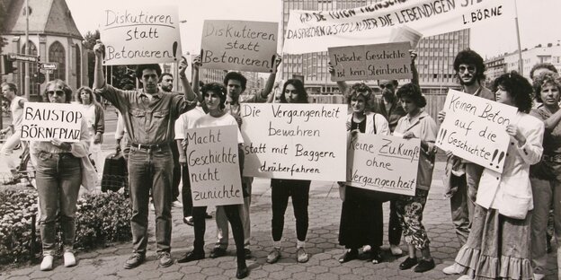 Menschen halten Protestschilder am Frankfurter Börneplatz hoch