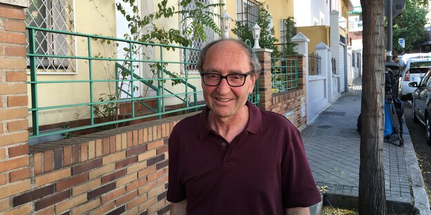Ein lächelnder Mann auf einem Bürgersteig Ein lächelnder Mann auf einem Bürgersteig