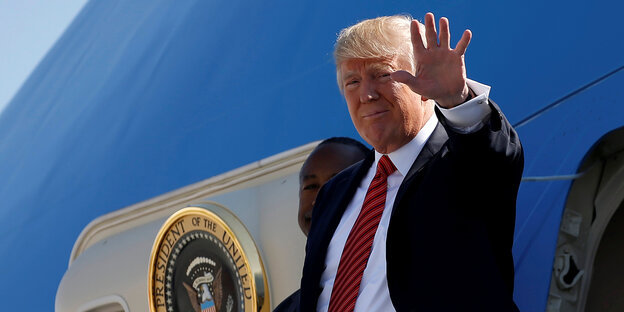 Trump steht vor der Airforce One und winkt - aber mit der linken Hand Trump steht vor der Airforce One und winkt - aber mit der linken Hand