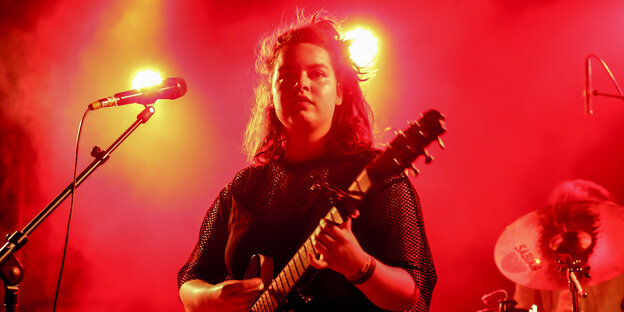 Ilgen-Nur mit einer Guitarre hinter einem Mikrofon Ilgen-Nur mit einer Guitarre hinter einem Mikrofon