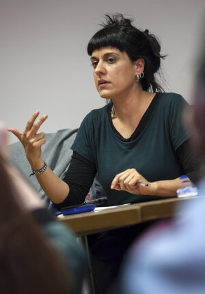 Eine Frau sitzt auf einem Stuhl und spricht Eine Frau sitzt auf einem Stuhl und spricht