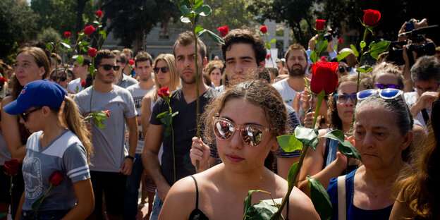 Menschen in Barcelona zeigen rote Rosen Menschen in Barcelona zeigen rote Rosen