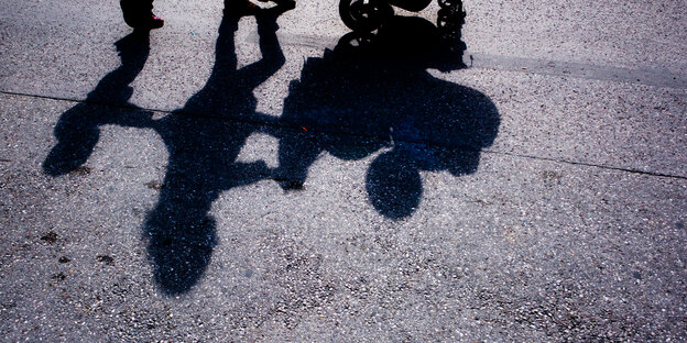 die Schatten mehrerer Kinder auf Asphalt die Schatten mehrerer Kinder auf Asphalt