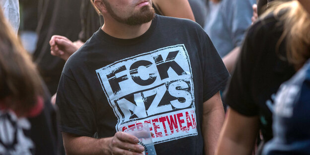 Ein Mann trägt ein T-Shirt mit der Aufschrift „FCK NZS“ Ein Mann trägt ein T-Shirt mit der Aufschrift „FCK NZS“