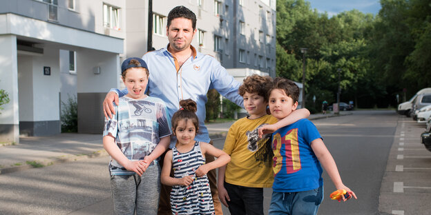 eine Familie posiert auf der Straße vor einem Haus für die Kamera eine Familie posiert auf der Straße vor einem Haus für die Kamera