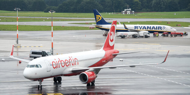 Ein Flugzeug der Air Berlin steht auf dem Rollfeld, dahinter ein Flugzeug der Fluglinie Ryanair Ein Flugzeug der Air Berlin steht auf dem Rollfeld, dahinter ein Flugzeug der Fluglinie Ryanair