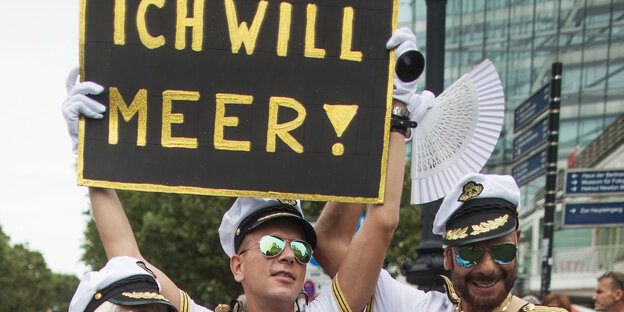 Als Seeleute verkleidete Männer bei einer Parade zum Christopher Street Day, sie halten ein Schild, auf dem steht: Ich will Meer! Als Seeleute verkleidete Männer bei einer Parade zum Christopher Street Day, sie halten ein Schild, auf dem steht: Ich will Meer!