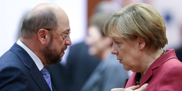 Martin Schulz und Angela Merkel stehen sich gegenüber und unterhalten sich Martin Schulz und Angela Merkel stehen sich gegenüber und unterhalten sich