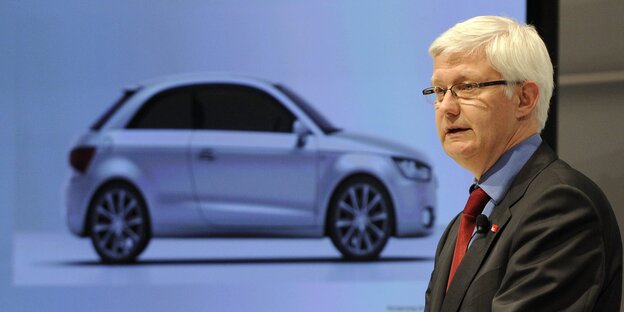 Werner Widuckel mit einem Bild eines Audis im Hintergrund Werner Widuckel mit einem Bild eines Audis im Hintergrund