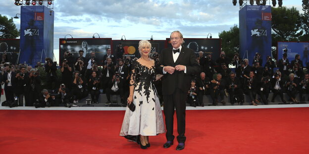 Im Vordergrund sind die Schauspieler Helen Mirren und Donald Sutherland auf dem roten Teppich zu sehen, im Hintergrund die Fotografen Im Vordergrund sind die Schauspieler Helen Mirren und Donald Sutherland auf dem roten Teppich zu sehen, im Hintergrund die Fotografen
