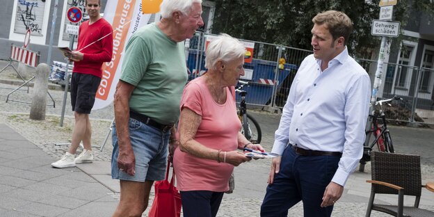 Ein Mann unterhält sich mit einem älteren Ehepaar Ein Mann unterhält sich mit einem älteren Ehepaar