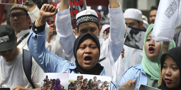 Indonesische Aktivisten skandieren mit erhobenen Fäusten Indonesische Aktivisten skandieren mit erhobenen Fäusten