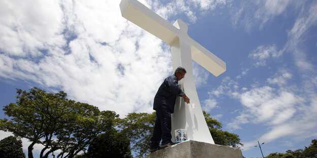 Ein Mann streicht ein Kreuz weiß an Ein Mann streicht ein Kreuz weiß an