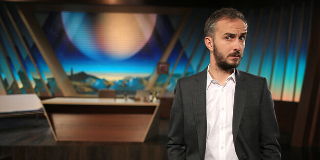 Ein junger Mann in Hemd und Sakko vor einem Fernsehstudio Ein junger Mann in Hemd und Sakko vor einem Fernsehstudio