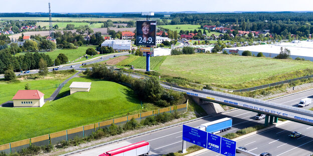 Straßen, Autos, Landschaft und ein Merkel-Plakat Straßen, Autos, Landschaft und ein Merkel-Plakat