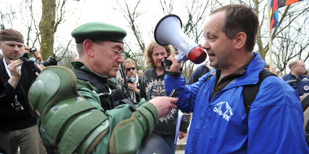 Monty Schädel mit Megafon diskutiert mit dem Einsatzleiter einer Demonstration Monty Schädel mit Megafon diskutiert mit dem Einsatzleiter einer Demonstration