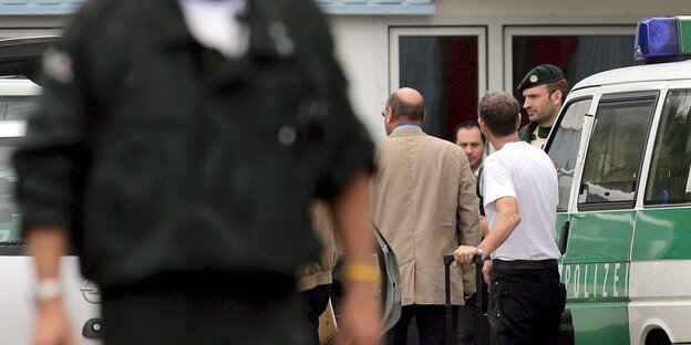 Polizeiautos und Polizisten vor einem Haus des Milli Görüs-Verbands Polizeiautos und Polizisten vor einem Haus des Milli Görüs-Verbands