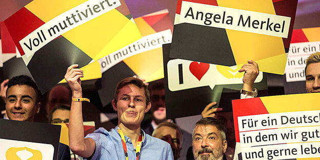 Junge Menschen halten Plakate bei einer CDU Veranstaltung hoch Junge Menschen halten Plakate bei einer CDU Veranstaltung hoch