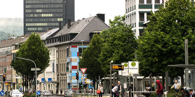 Blick auf eine Häuserzeile mit Bäumen im Vordergrund, im Hintergrund ein Hochhaus Blick auf eine Häuserzeile mit Bäumen im Vordergrund, im Hintergrund ein Hochhaus